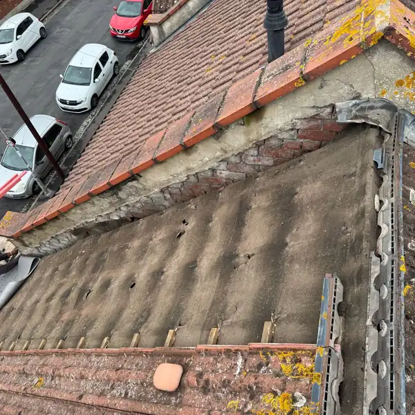 Clay tile roof partly stripped back to worn felt underlay before renewal