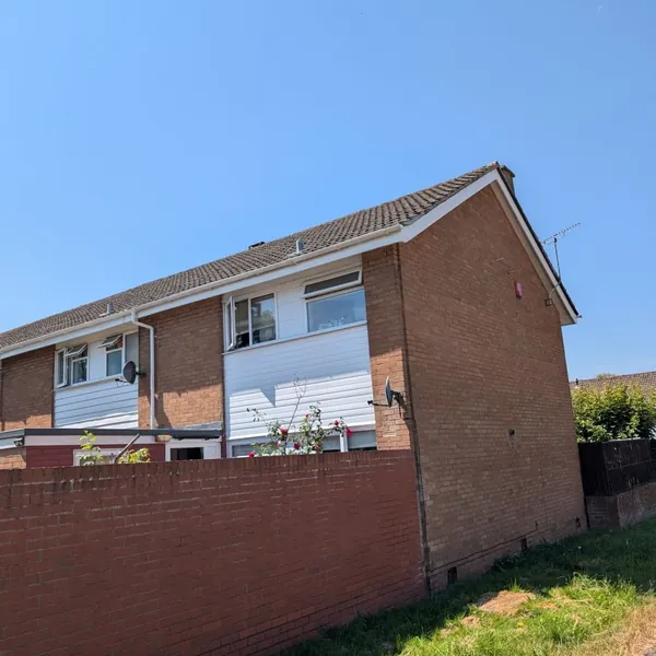 Semi-detached brick house with a concrete tile roof, photographed during a roof inspection